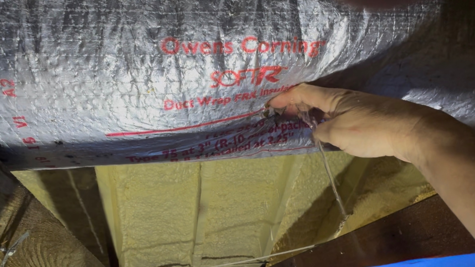 Water draining from saturated duct wrap as it is compressed from underneath.